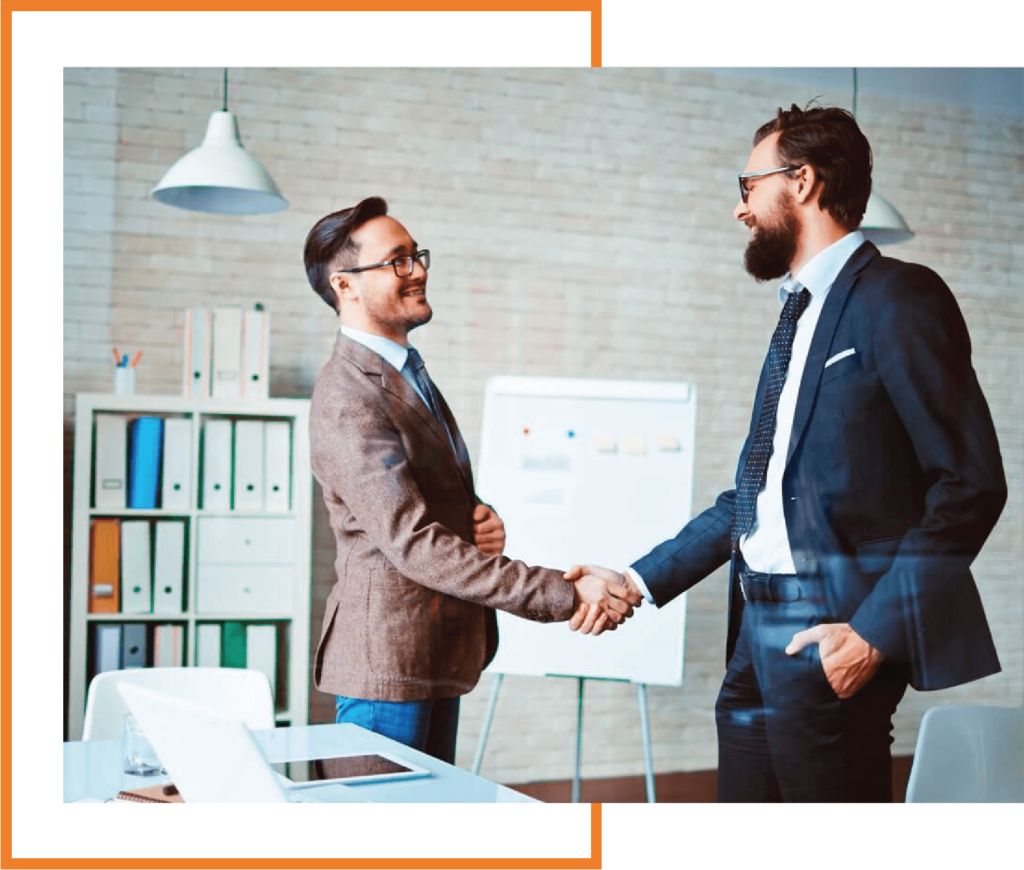 Two men shaking hands over a desk