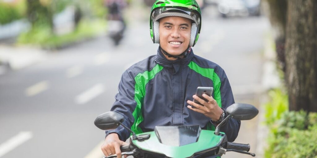 Motorcycle driver wearing helmet using phone
