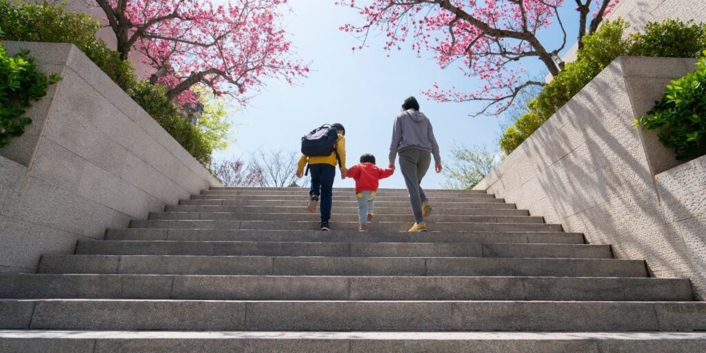 2 adult and a kid climbing steps