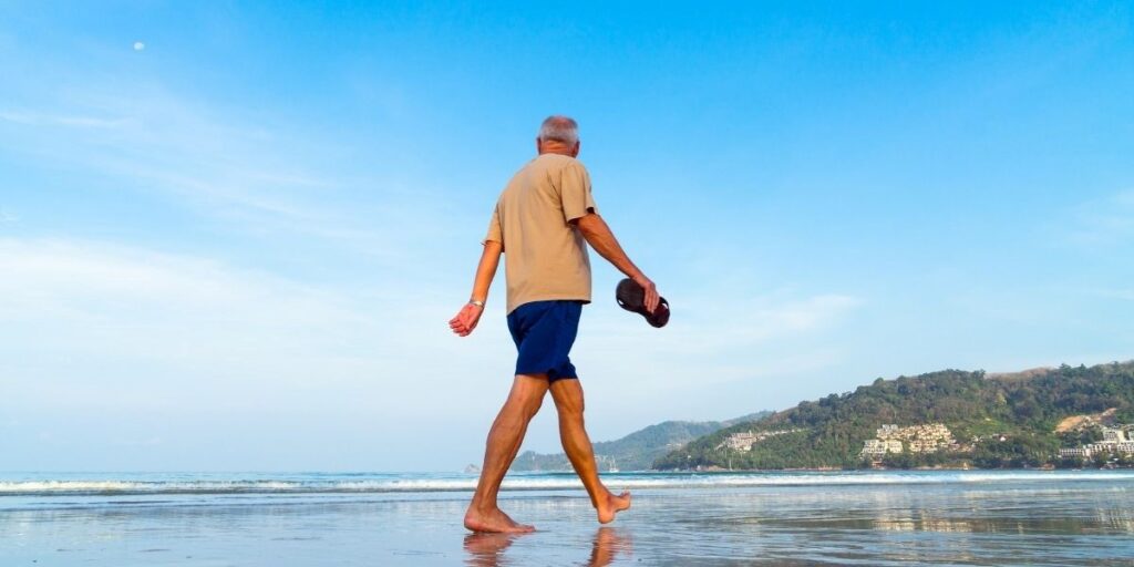 retired man waking on the beach