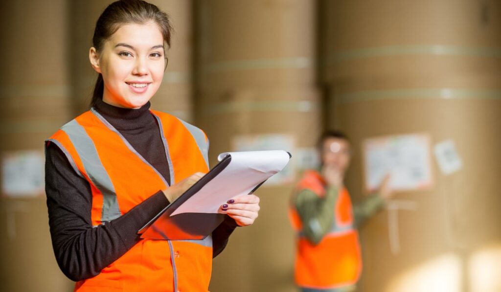 orange jacket female worker noting